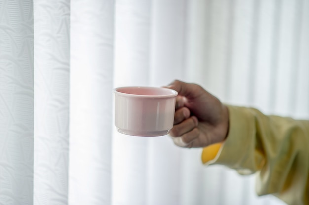 Handbild und Kaffeetasse Trinkendes Konzept des Kaffees