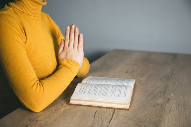 Handbuch der betenden Frau im dunklen Raum