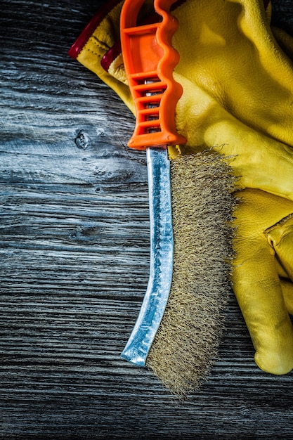 Handdrahtbürsten-Schutzhandschuhe auf Vintage-Holzbrett