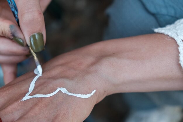 Foto handfoto einer frau, die ihre hand malt