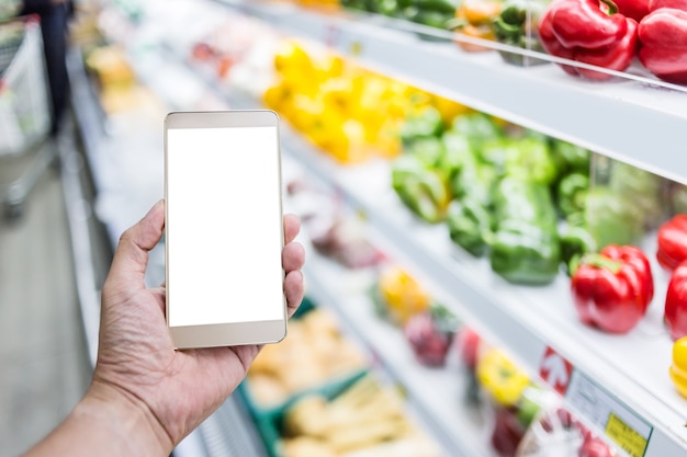 Handgebrauch Smartphone mit Unschärfehintergrund des Supermarktes