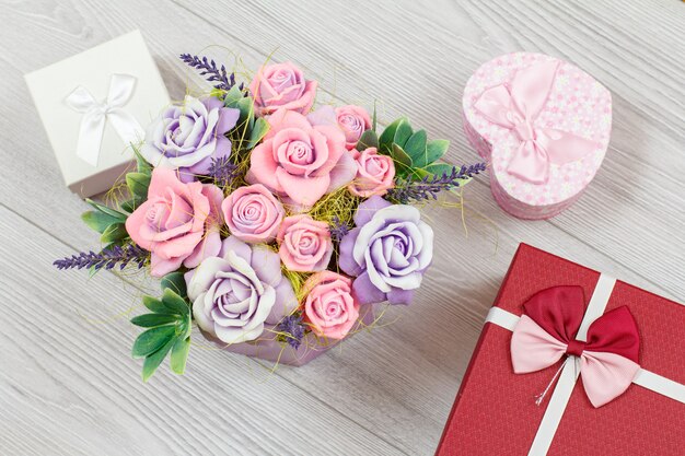 Foto handgefertigte blumen und geschenkboxen auf der grauen holzoberfläche