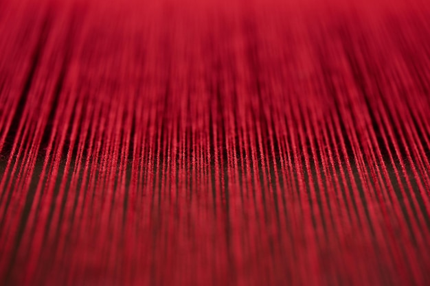 Handgefertigte Textilien, Handwebstoffe aus roten Garnen und Fäden, Spinnmaschine