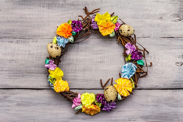 Foto handgefertigter osterweidenkranz mit wachteleiern und handgemachten blumen