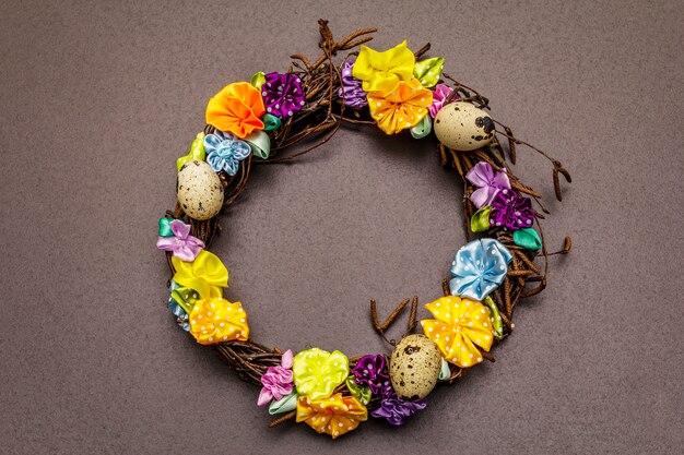 Handgefertigter Osterweidenkranz mit Wachteleiern und handgemachten Blumen