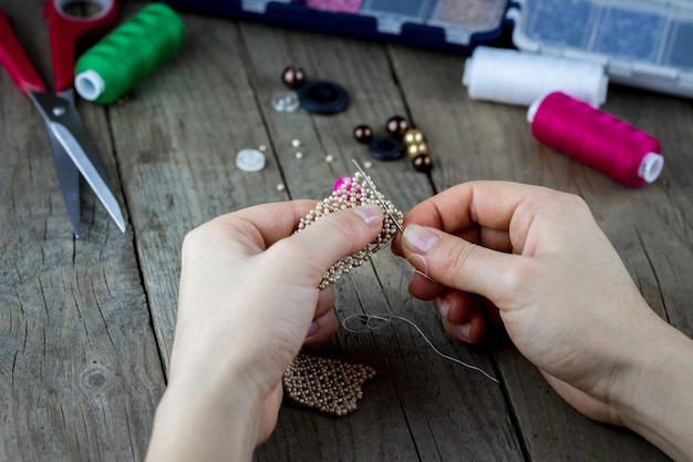 Handgefertigter Schmuck aus Perlen mit den Händen.