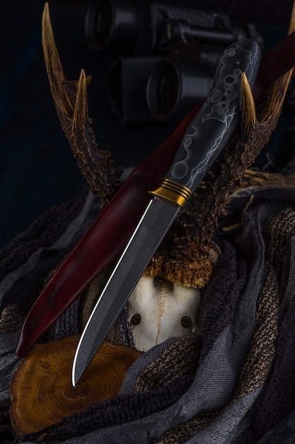 Handgefertigtes Jagdmesser aus Damaststahl liegt auf den Hörnern