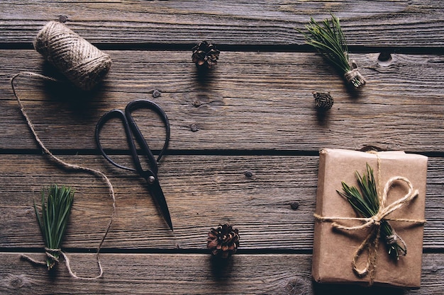 Handgemachte Bastelgeschenke aus Papier mit Band an den Weihnachtsfeiertagen und Geschenken. Auf Holzhintergrund,