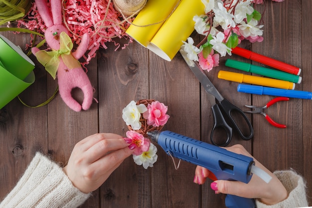 Handgemachte Blumen der Frau kleben mit Schmelzpistole