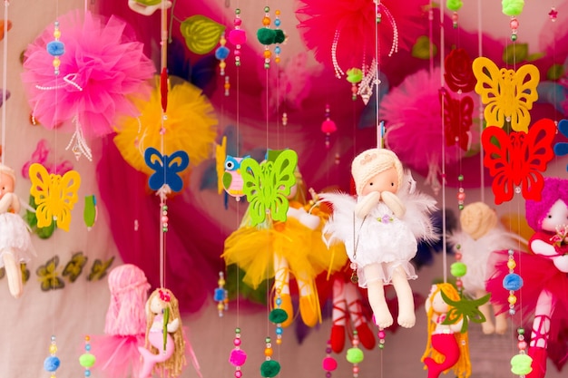 Handgemachte bunte Puppenschmetterlinge und andere Spielzeuge, die an Fäden im Flohmarkt hängen