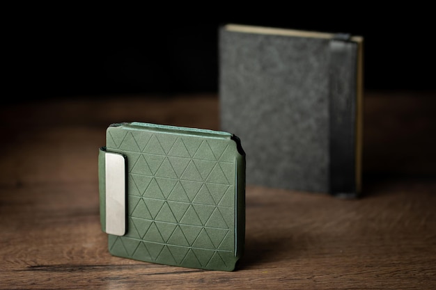 Handgemachte grüne Brieftasche aus echtem Leder auf Holzhintergrund Nahaufnahme Draufsicht