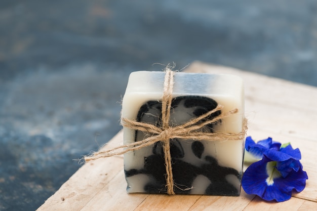 Handgemachte indigo-seife und schmetterling pinkeln blume auf holz