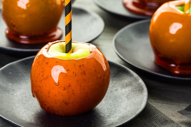 Handgemachte orangefarbene Süßigkeitsäpfel für Halloween.