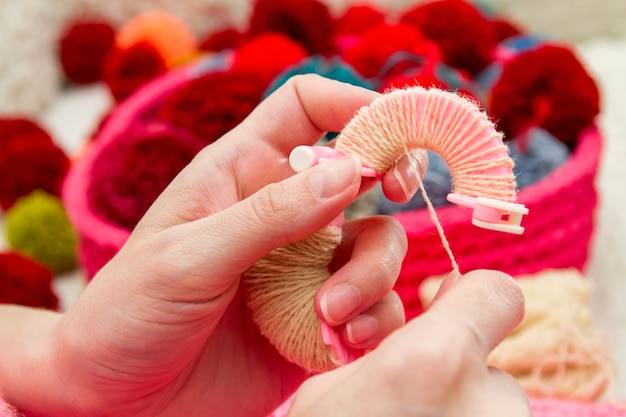 Handgemachte Pompons. Der Prozess der Herstellung von Pompons aus Fäden von Frauen