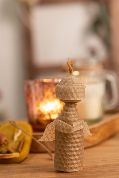 Handgemachte Weihnachtskerze in einem weihnachtlichen Interieur mit Kerzen herum