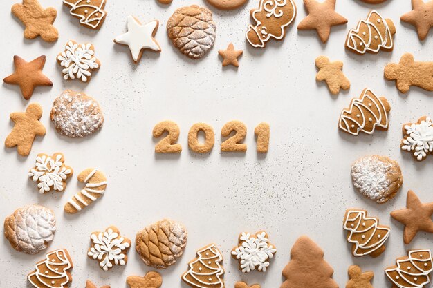 Handgemachte weihnachtsplätzchen angeordnet um datum 2021 auf weißem hintergrund. fröhliche weihnachten. von oben betrachten. flach liegen.