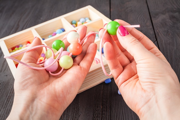 Handgemachtes Knopfarmband. Satz bunte Knöpfe, Zangen. DIY Armreif Schmuck Idee. Einfach kreatives Basteln machen