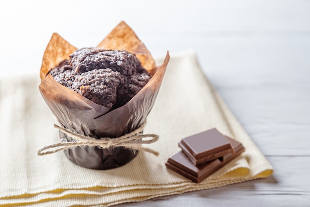 Handgemachtes Schokoladenmuffin mit Stücken Schokolade auf Holztisch