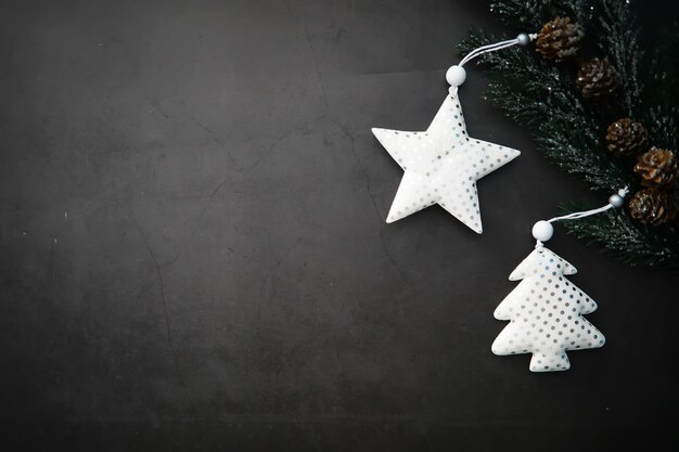 Handgemachtes Spielzeug des immergrünen Baumes, Schneeflocken, Kugeln und Tannenzweig auf Steinhintergrund, Weihnachtsgrußkarte mit Platz für Textwunsch