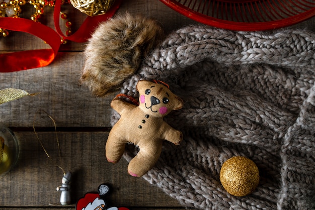 Handgemachtes Teddybär-Weihnachtsspielzeug, warme Wollmütze auf Holz