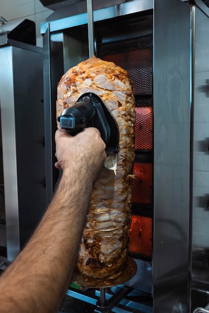 Handgeschnittene Kebab-Rolle mit einem Schneidemaschine