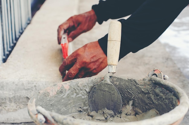 Foto handgeschnittener maurer, der im freien arbeitet