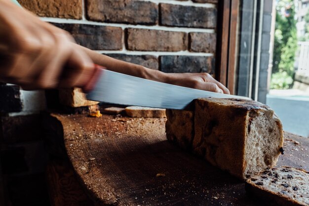 Foto handgeschnittenes brot, das auf dem tisch geschnitten wird