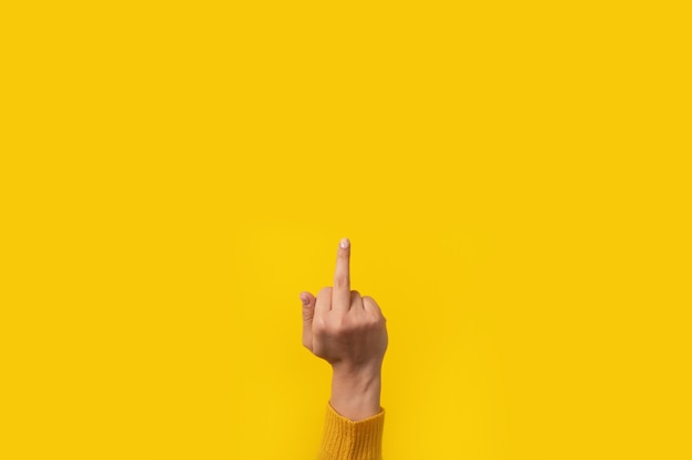 Handgeste, fick dich Symbol, Mittelfingerzeichen über gelbem Hintergrund