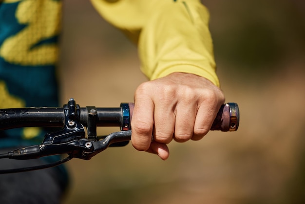 Handgriff und Fahrrad mit einem männlichen Athleten oder Radfahrer, der im Freien für Fitnessübungen oder Cardio reitet. Workout-Gesundheitsgriff mit einem männlichen Fahrradfahrer, der sich im Freien für Ausdauer an einem Lenker hält