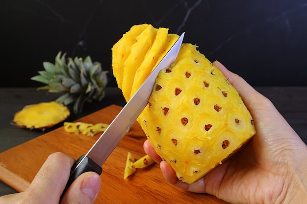 Handhaltemesser zum schälen und entfernen der harten und stacheligen augen einer frischen reifen ananas