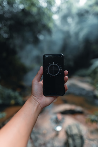 Handheld-Smartphone in Wald und Kompass, Kompass im Telefon