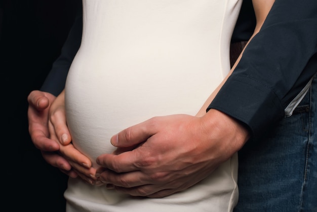 Handkerl auf dem Bauch eines schwangeren Mädchens