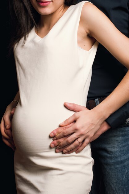 Handkerl auf dem Bauch eines schwangeren Mädchens