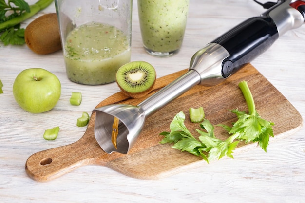 Handmixer zum Mischen von organischen rohen frischen Früchten für die Herstellung von Vitamindiät-Smoothie, gesundem Essen. Nahansicht.