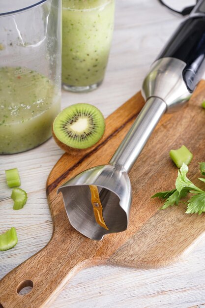 Foto handmixer zum mischen von organischen rohen frischen früchten für die herstellung von vitamindiät-smoothie, gesundem essen. nahansicht.