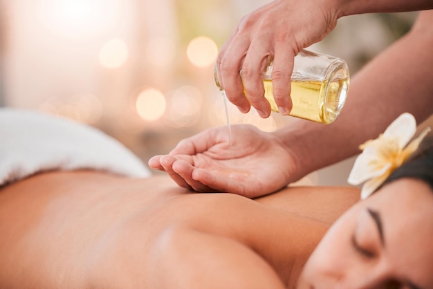 Handöl und Massage auf Frau in einem Spa für Wellness, Entspannung und Stressabbau mit Rückenmassage und Masseurin Luxuriöse Rücken- und Mädchenhände des Therapeuten mit Produkt für Körperhaut- und Muskeltherapie