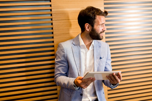 Handome junger Mann mit Tablette im Büro