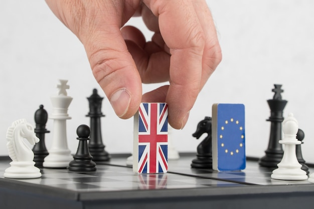 Handpolitik erhebt die Figur mit der Flagge Großbritanniens Das Konzept des politischen Spiels und der Strategie