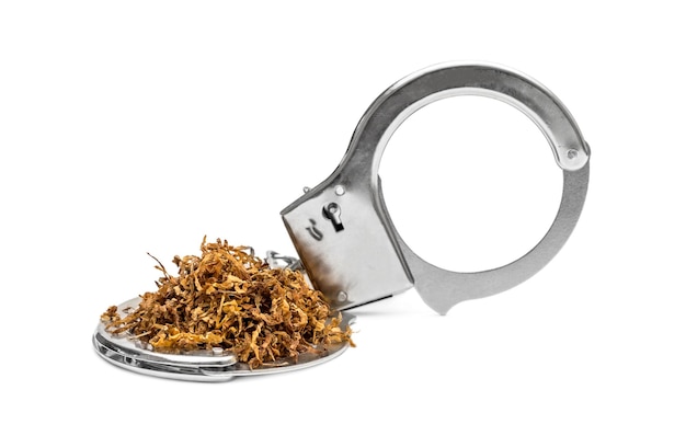 Handschellen mit geschnittenem Tabak auf weißem Tabaksucht