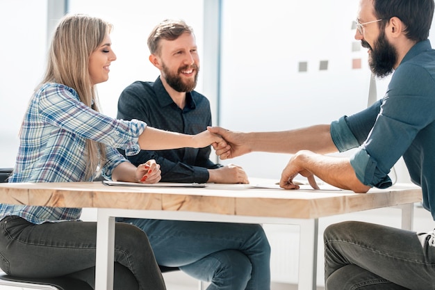 Foto handschlag der lächelnden geschäftspartner während eines geschäftstreffens