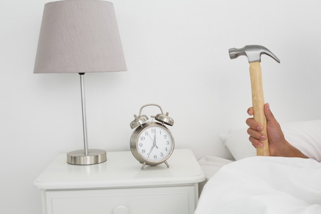 Handschlagwecker mit Hammer im Bett