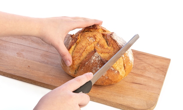 Handschneiden traditionelles rundes Brot auf Schneidebrett auf weißem Hintergrund