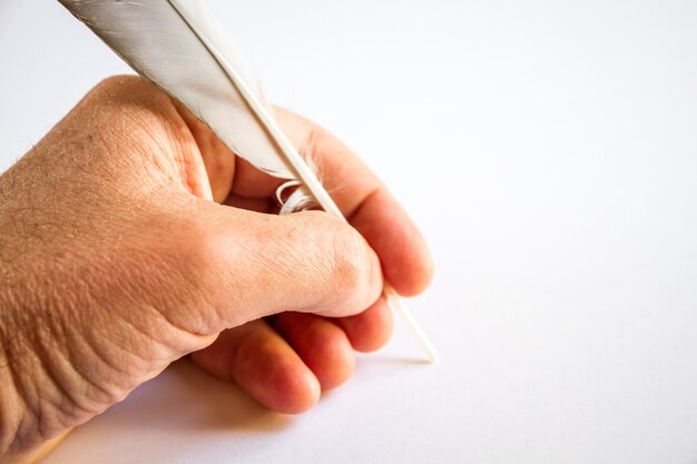 Handschrift mit einer Vogelfeder auf weißem Hintergrund