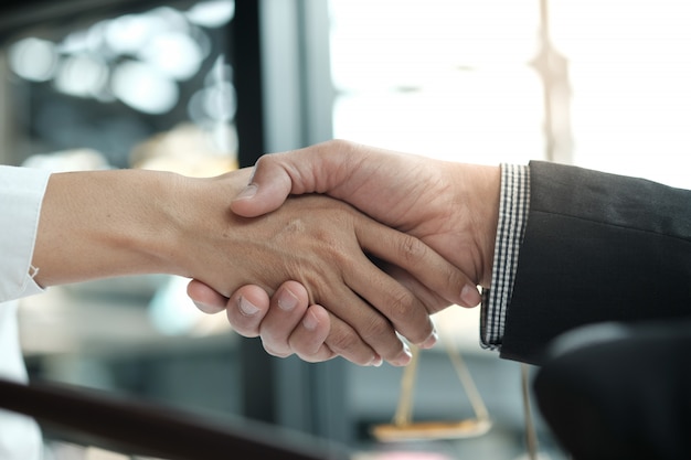 Handshake de advogado com o cliente. Parceria do negócio que encontra o conceito bem sucedido.