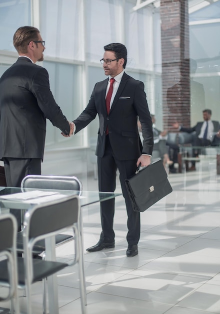 Handshake-Geschäftsleute in der Bankfiliale