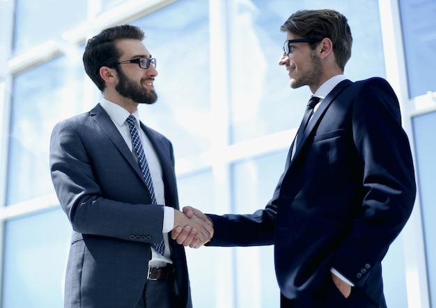 Handshake-Geschäftspartner in einem hellen Bürofoto mit Kopierraum