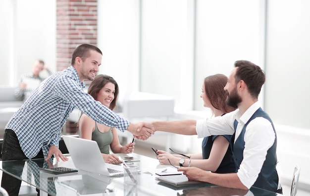 Handshake Geschäftspartner über den Schreibtisch im Büro.Konzept der Zusammenarbeit