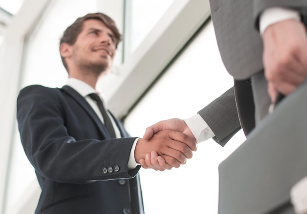 Handshake-Geschäftspartner von unten im Büro