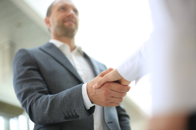 Foto handshake-konzept der geschäftspartnerschaft. foto zwei mitarbeiter handshake-prozess. erfolgreiches geschäft nach einem großartigen treffen.