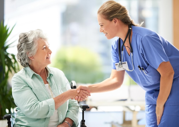 Handshake-Krankenschwester und ältere Frau im Rollstuhl mit medizinischen Ergebnissen und Erfolgsmeldungen zu chirurgischen Eingriffen. Gesundheitsversorgung im Krankenhaus und Klinik mit Frauen und Pflegepersonal mit Betreuung und Unterstützung der älteren Person